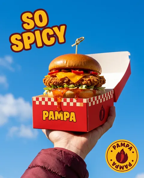 Pampa : burger dans sa boîte tenu à bout de bras sur fond de ciel bleu, So Spicy